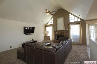 Great Room is warmed by a brick fireplace with rai