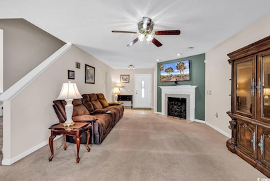 Living room with a ceiling fan, light carpet, base