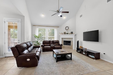 Tiled living area with ceiling fan, high vaulted 
