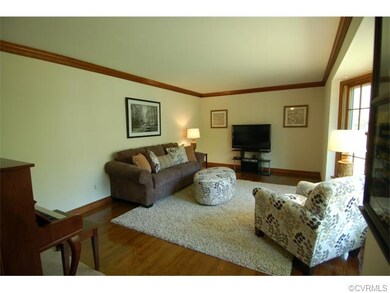The bright living room has a large bay window whic