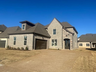 French country inspired facade with driveway, bric