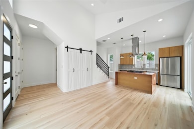 Kitchen featuring a barn door, brown cabinets, re