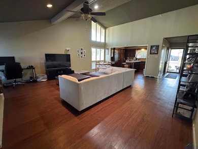Living area featuring high vaulted ceiling, dark w