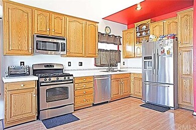 Open kitchen with oak cabinets and stainless steel