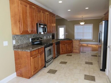 Another angle of this wonderful kitchen, tile floors, tile backsplash, stainless steel appliances, pantry and open for entertaining