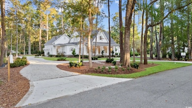 View of front of property featuring curved driveway, covered porch, and a front lawn