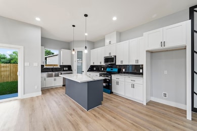 Gourmet kitchen with quartz countertops and custom backsplash