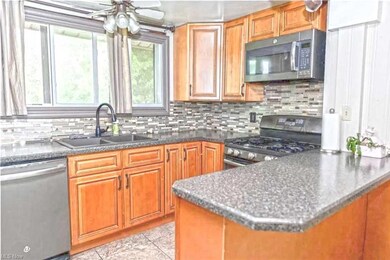 Kitchen with backsplash, brown cabinets, appliance