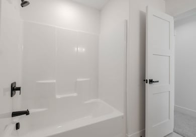 (PHOTO OF SIMILAR HOME)Bathroom with bathing tub / shower combination and baseboards
