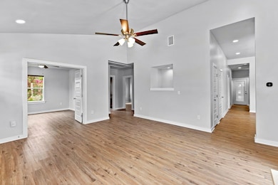 Unfurnished living room featuring a ceiling fan, 