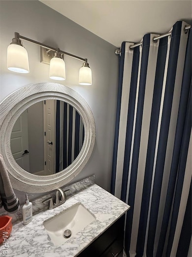 Full bath with a shower with shower curtain and vanity