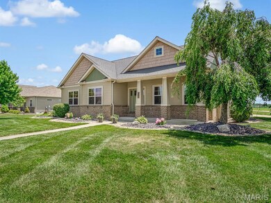 Craftsman-style home with brick siding, a front lawn, a porch, and roof with shingles