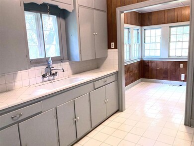 Kitchen featuring gray cabinetry, wooden walls, a