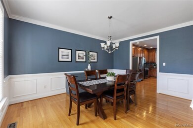 Formal dining room features hardwood floors, chand