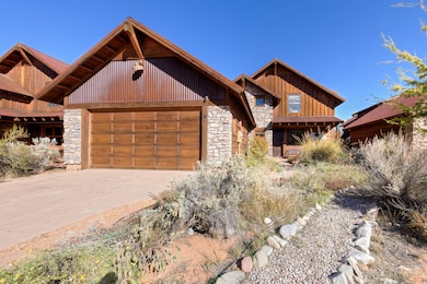 View of front of home featuring stone siding, an attached garage, and driveway