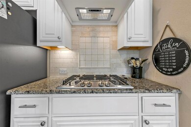 Kitchen featuring dark stone countertops, white ca