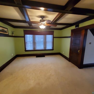 Unfurnished room featuring light carpet, beam ceil