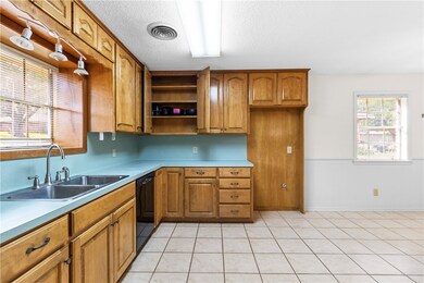 Kitchen featuring brown cabinets, dishwasher, open
