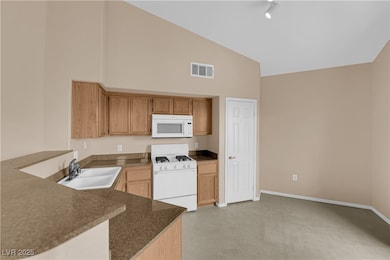 Kitchen with high vaulted ceiling, a sink, visible