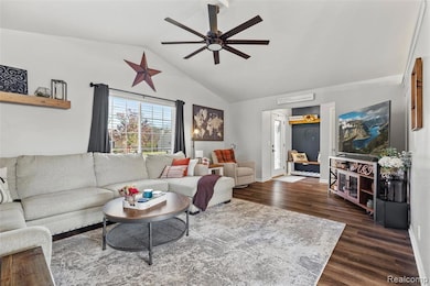 Living room with vaulted ceiling, dark wood-style floors, and a ceiling fan