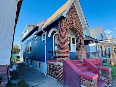 View of side of home featuring a porch and brick siding