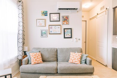 Living area featuring a barn door, an AC wall uni
