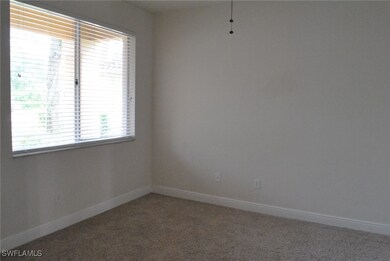 Unfurnished room featuring light carpet and baseboards