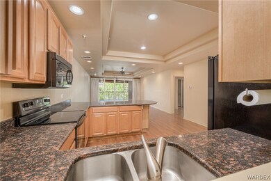 Kitchen featuring kitchen peninsula, ceiling fan,