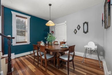 Dining room with stairs and dark wood-style floors