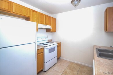 Kitchen with sink, white appliances, and light til