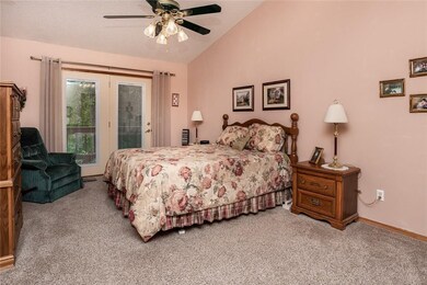 Master bedroom with vaulted ceilings and glass pat