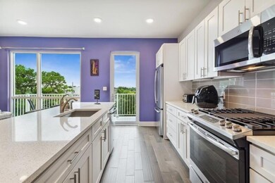Sparking quartz countertops, plenty of cabinetry and stainless appliances fill the kitchen