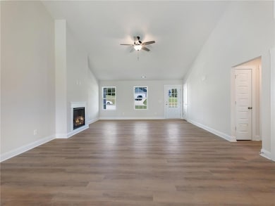 Unfurnished living room with ceiling fan and dark 