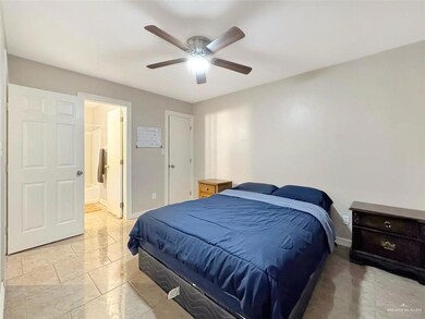 Bedroom with baseboards, ceiling fan, and ensuite bathroom