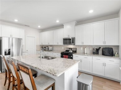 Kitchen featuring sink, white cabinetry, stainless