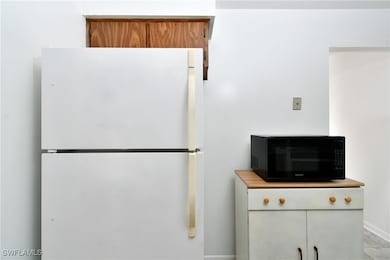 Kitchen view of black microwave, freestanding refr
