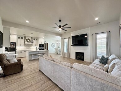 Living room featuring a large fireplace, light woo