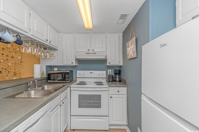 Kitchen featuring white appliances, white cabinetr