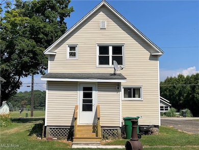 Rear view of property featuring entry steps and a yard
