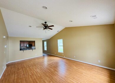 Unfurnished living room featuring lofted ceiling, light wood-type flooring, and ceiling fan