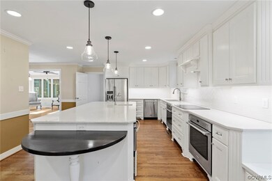 Kitchen with a kitchen island with sink, white cab