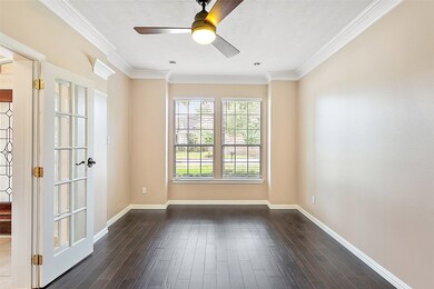 Study has French doors, gorgeous hardwood floors, double crown molding, recessed lights and fan.