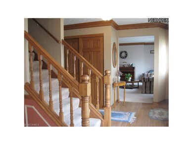 Foyer entry has hardwood floor and crown molding