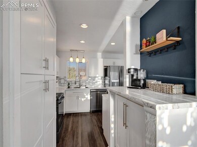 Kitchen with dark wood-type flooring, appliances w