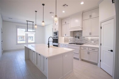 Kitchen with white cabinets, custom range hood, a 