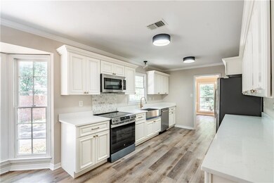 Kitchen featuring baseboards, appliances with stai