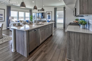 Kitchen featuring open floor plan, decorative light fixtures, dark wood-style flooring, and recessed lighting