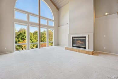 Unfurnished living room featuring carpet flooring, high vaulted ceiling, and a high end fireplace