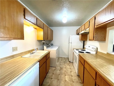 Kitchen featuring white appliances, separate washe
