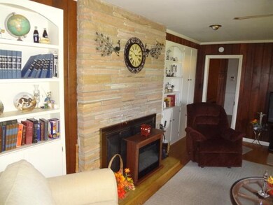 Fire place in den with build in book cases on both sides.